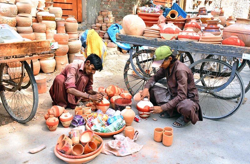 Workers busy coloring clay-made pots