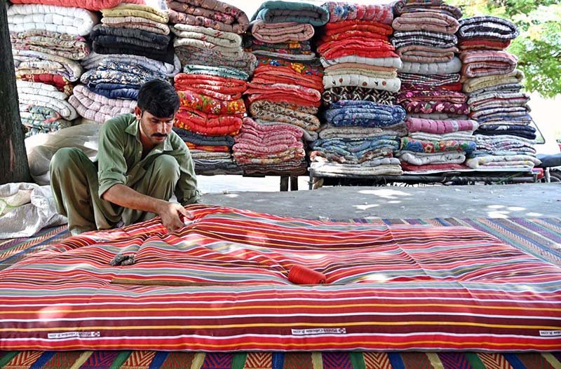 worker busy stitching quilt customers